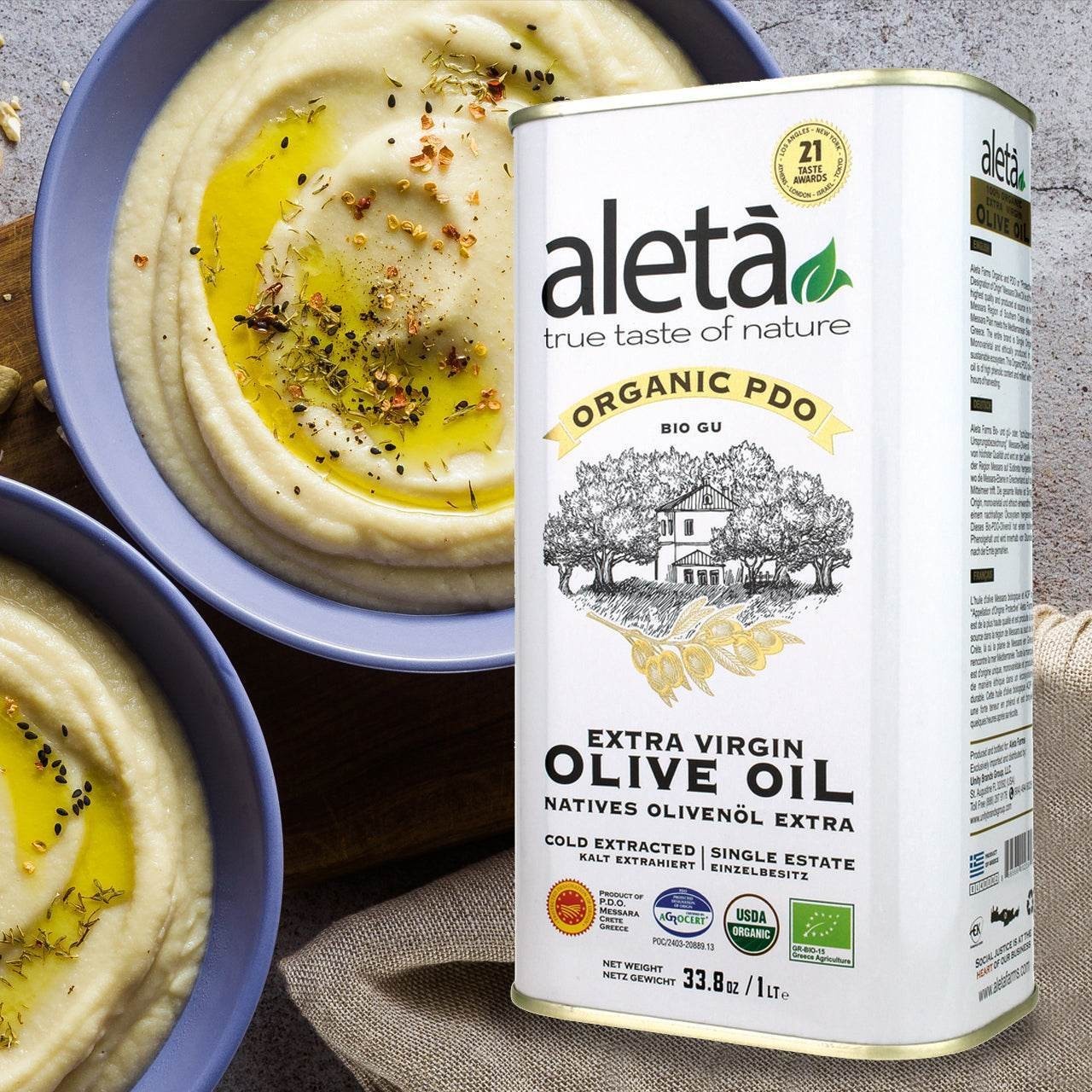 ELLORA FARMS Aleta organic PDO extra virgin olive oil tin next to bowls of creamy hummus drizzled with olive oil