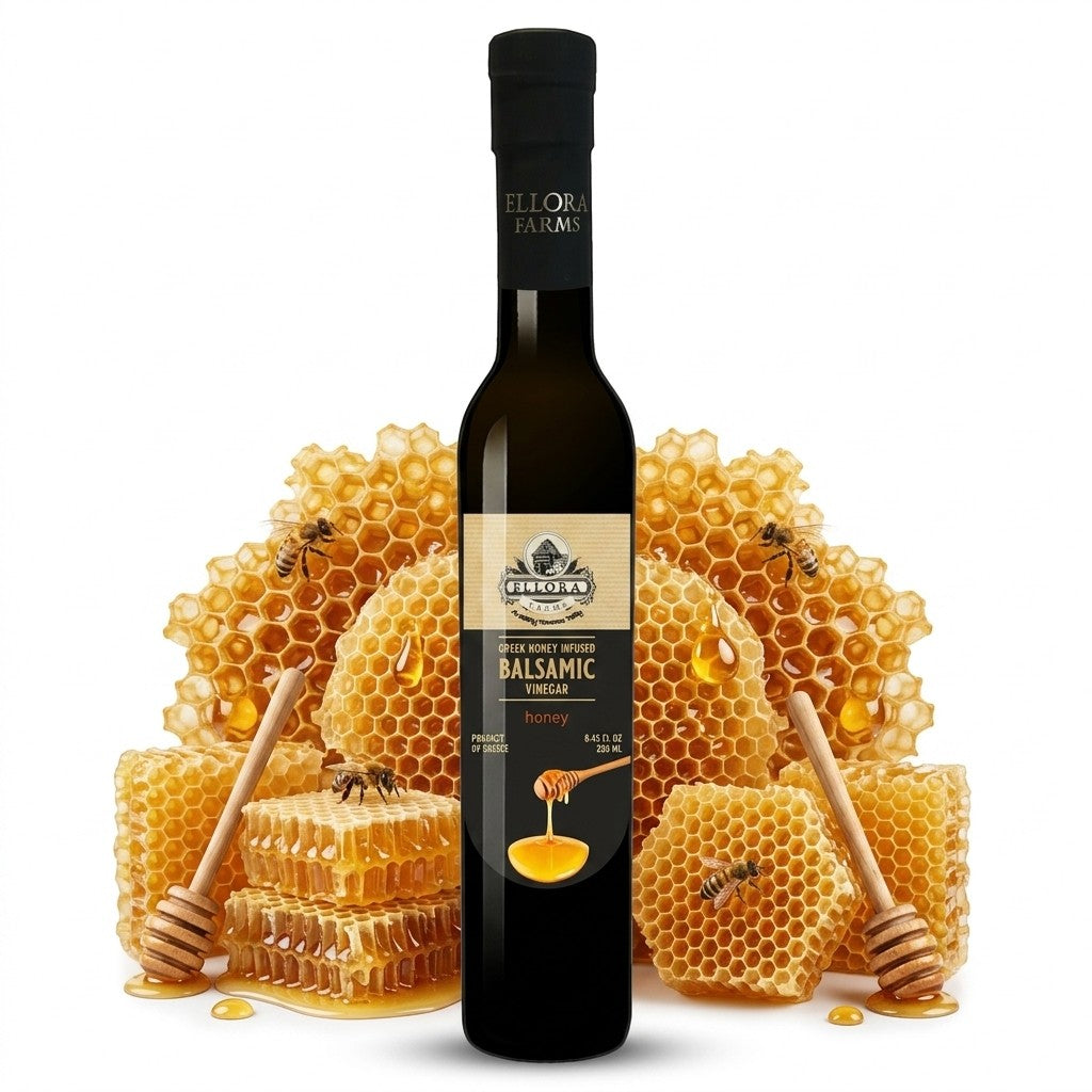 ELLORA FARMS Greek honey infused balsamic vinegar bottle displayed with honeycomb and wooden honey dippers.